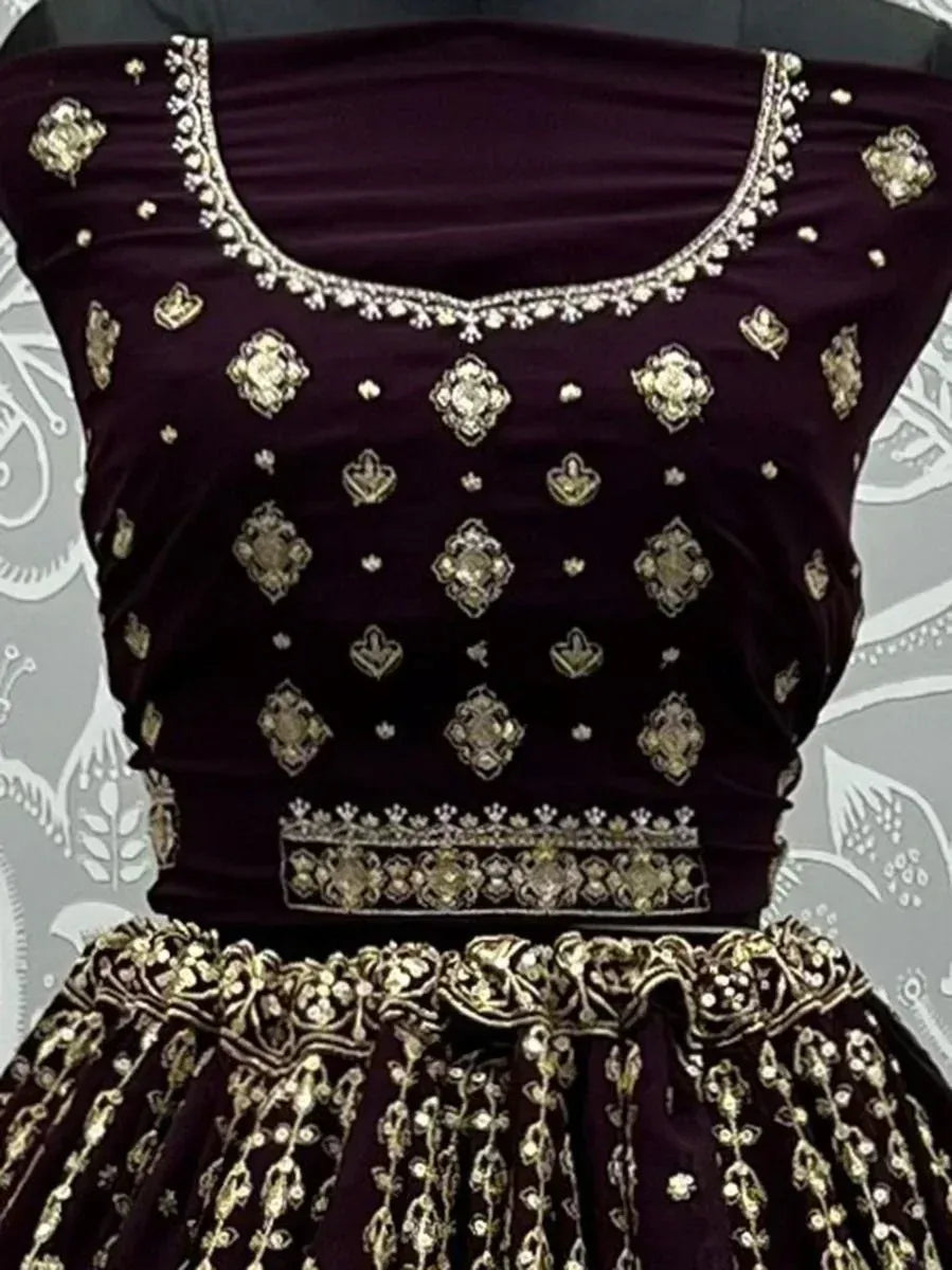 Elegant maroon velvet lehenga choli with gold embroidery and stone work, perfect for weddings and festive occasions.