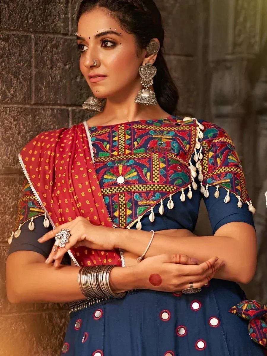 Woman in embroidered blue lehenga choli with red dupatta, traditional Indian ethnic wear