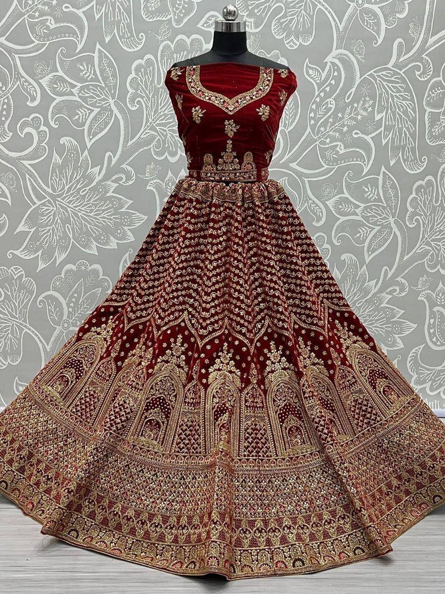 Maroon velvet lehenga choli with gold embroidery, perfect for weddings and festive occasions.