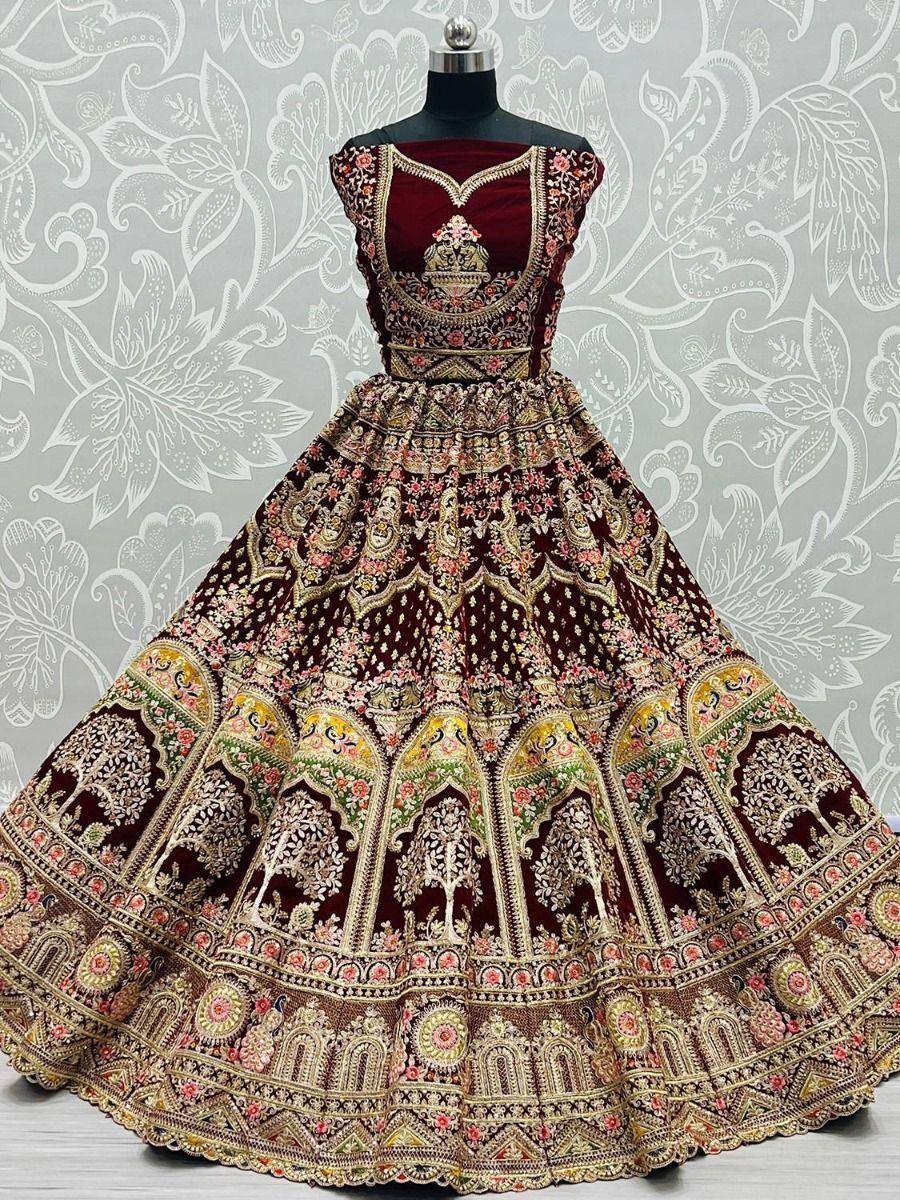 Maroon velvet designer lehenga choli with intricate gold embroidery and floral motifs, perfect for weddings