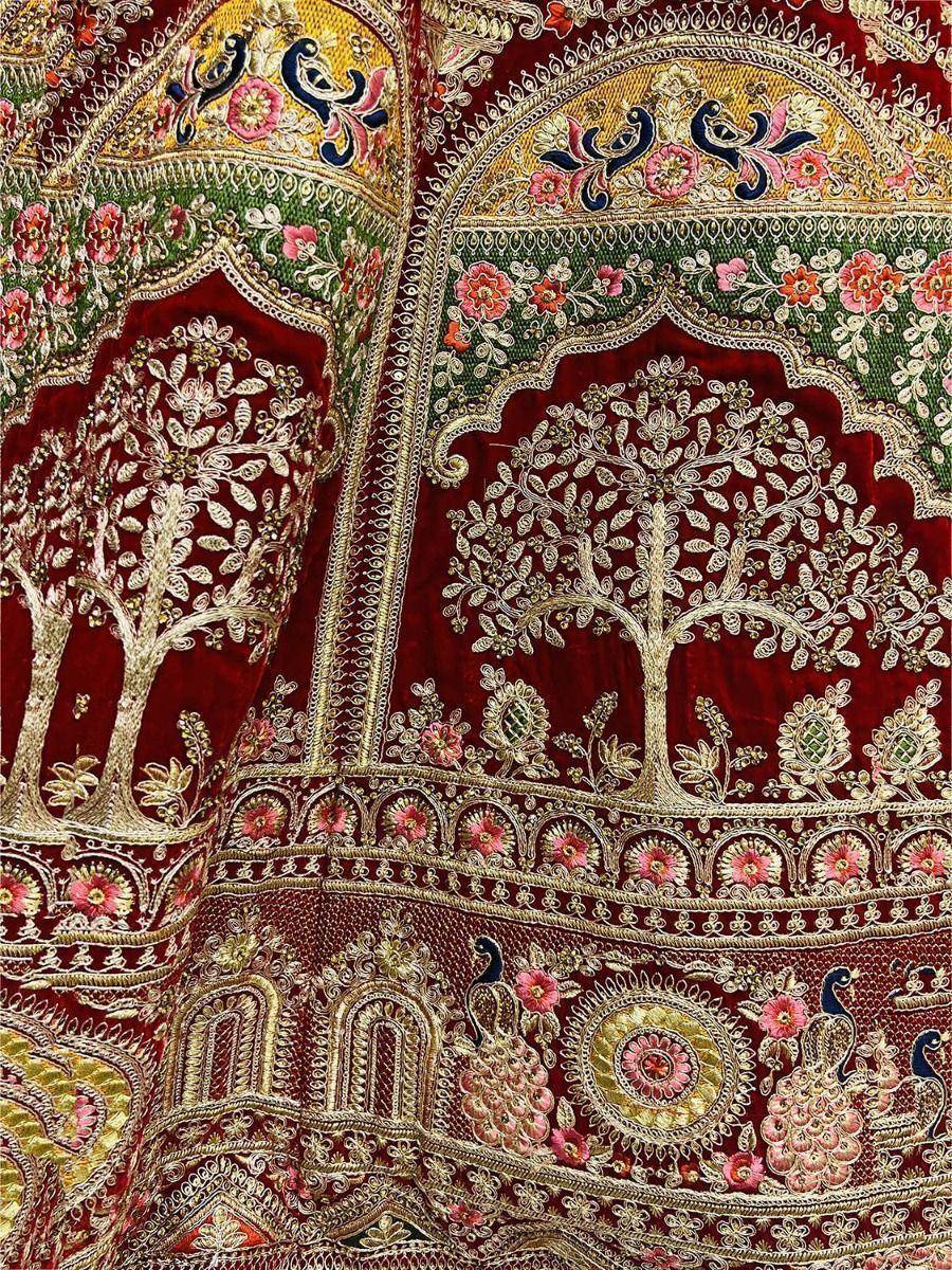 Richly embroidered maroon lehenga with gold tree and peacock motifs, perfect for Indian ethnic wear.