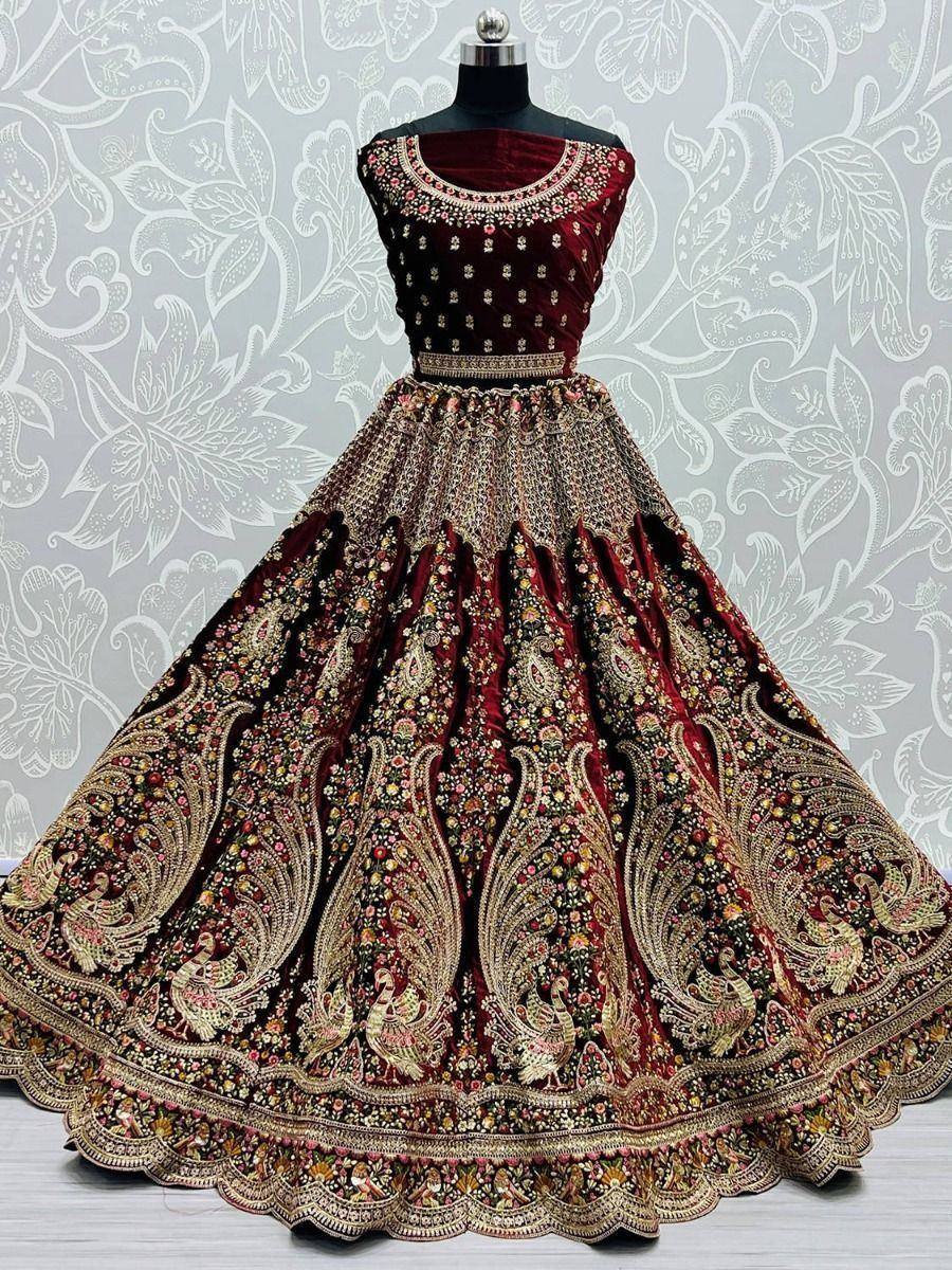 Maroon velvet lehenga choli with heavy gold embroidery and peacock motifs, ideal for weddings and festivals