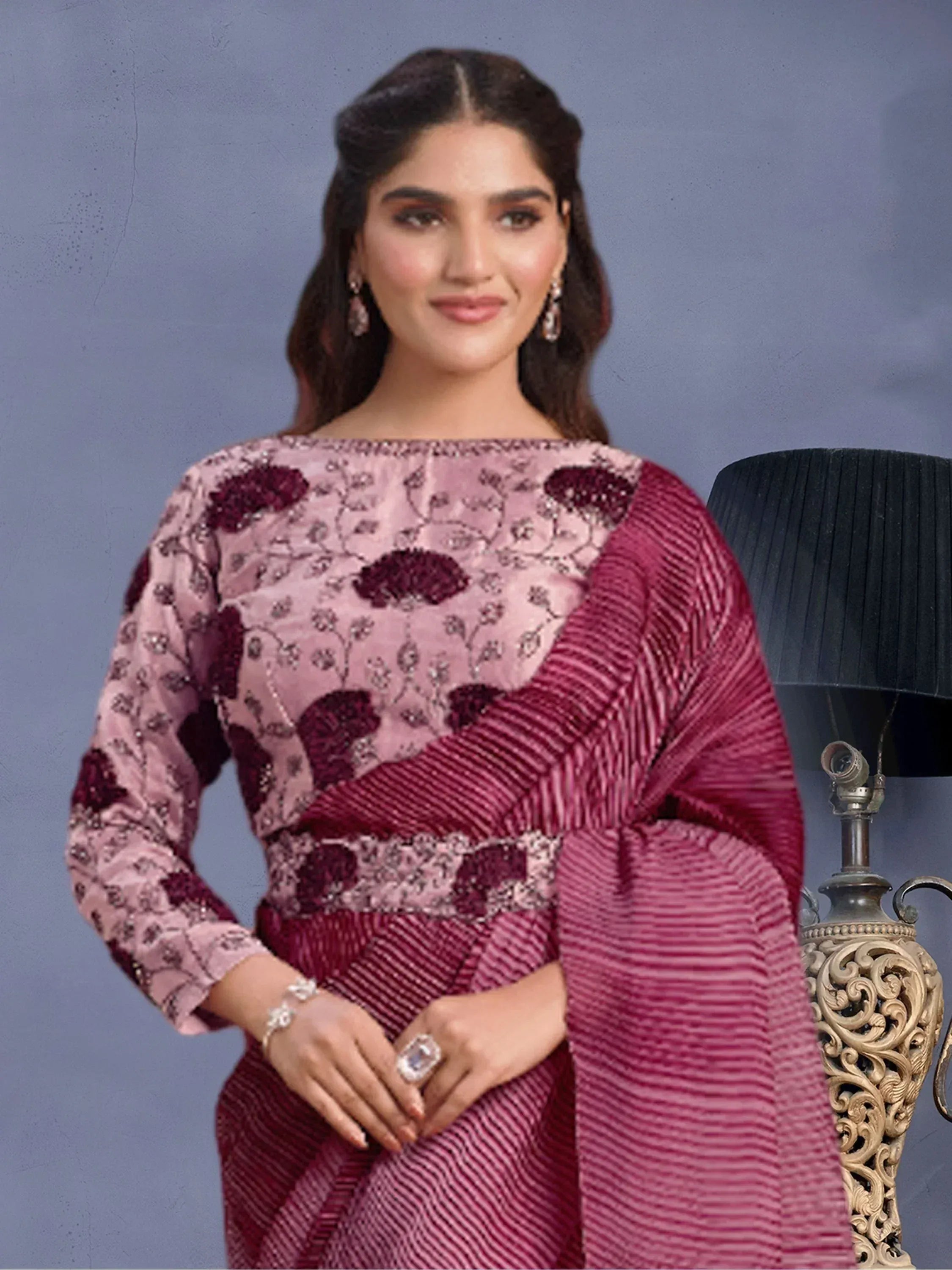 Woman in elegant pink and maroon embroidered ethnic gown with floral detailing, perfect for festive occasions.