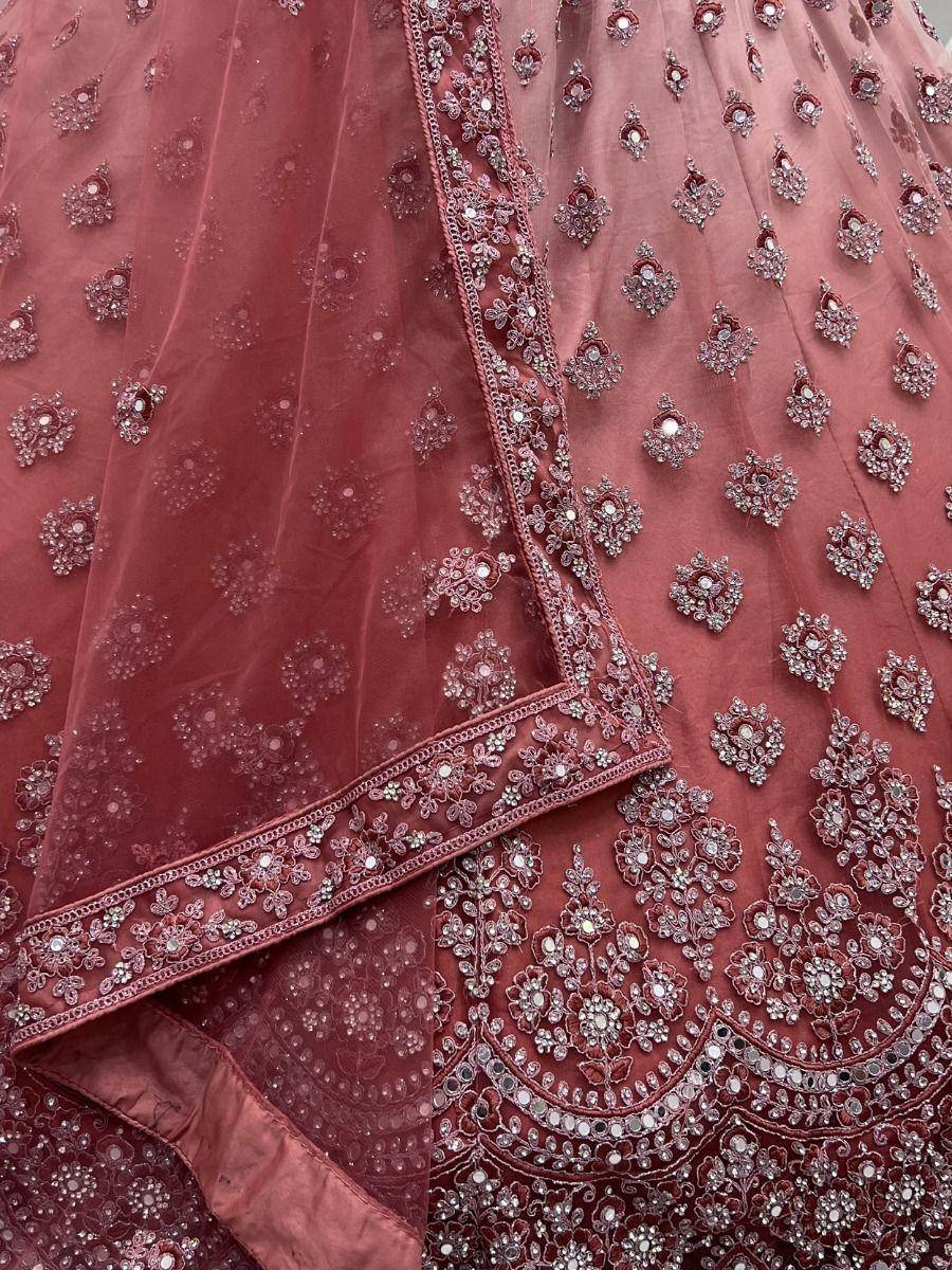 Dusty rose designer lehenga choli with intricate floral embroidery and mirror work, perfect for weddings.