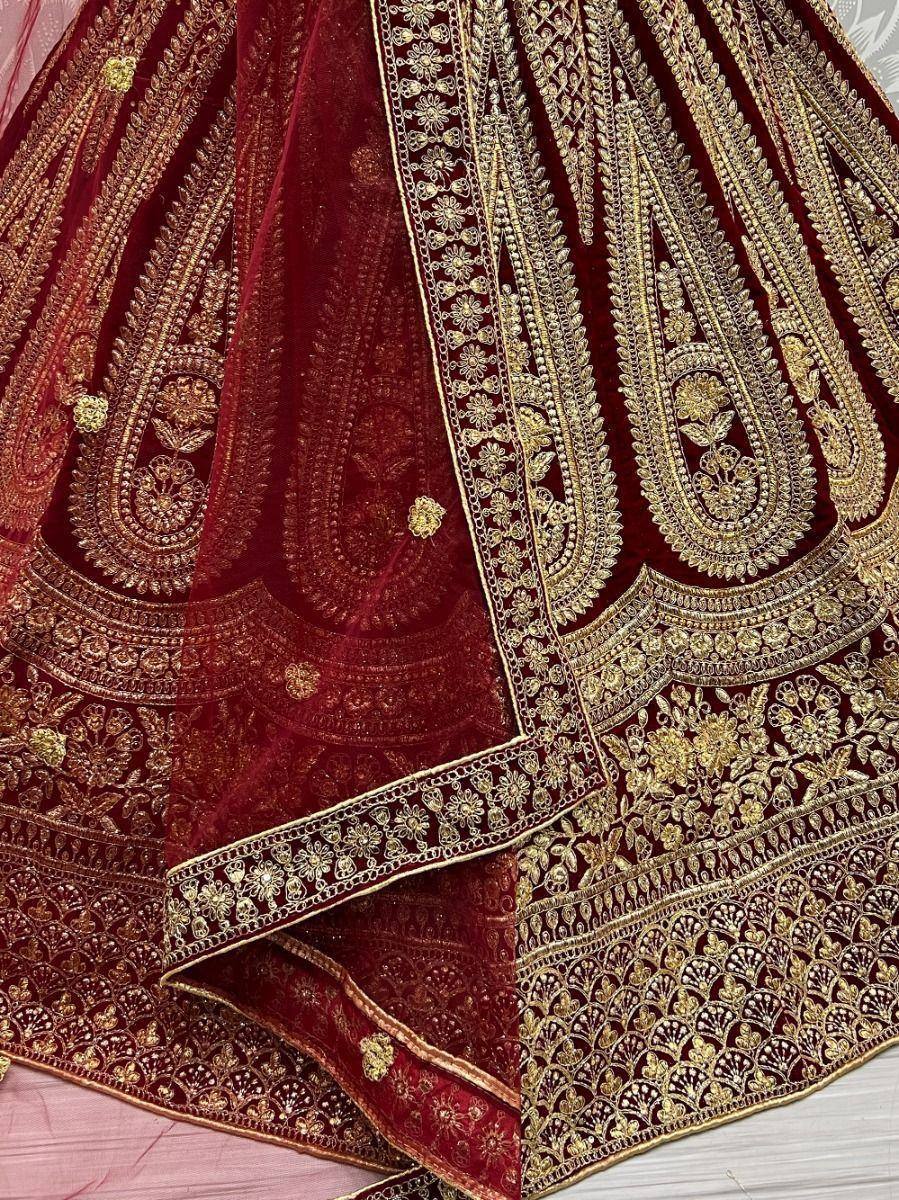Rich maroon velvet lehenga with intricate gold embroidery and floral motifs, perfect for Indian weddings.
