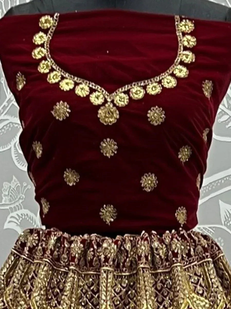 Maroon velvet lehenga choli with gold floral embroidery and detailed border, perfect for Indian ethnic wear.