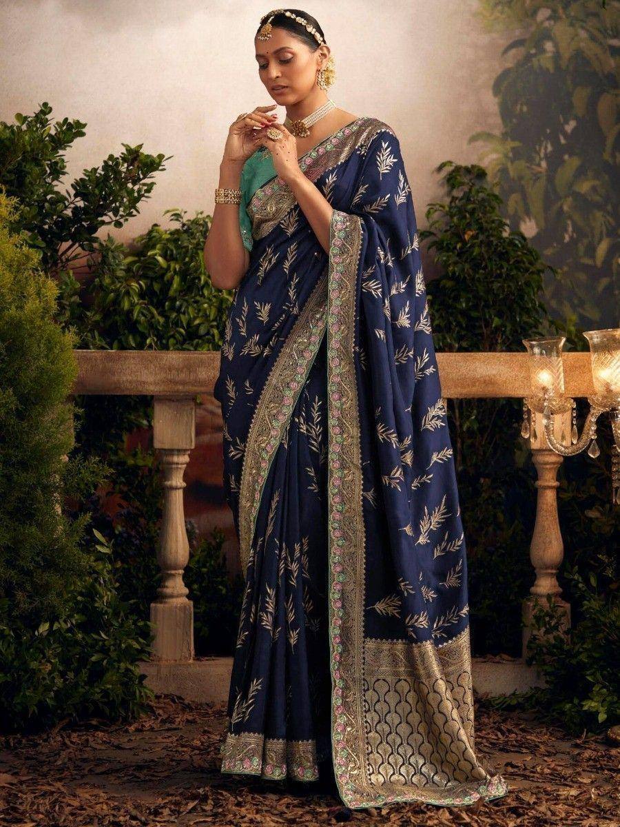 Navy blue embroidered saree with gold leaf motifs and embellished border, styled with traditional jewelry for ethnic occasions