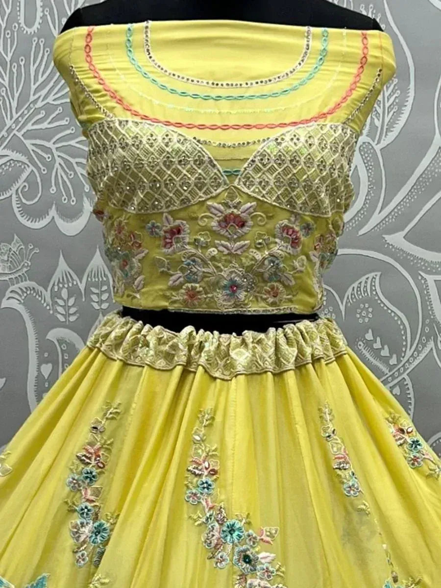 Yellow embroidered lehenga choli with floral detailing and off-shoulder blouse, perfect for Indian ethnic occasions