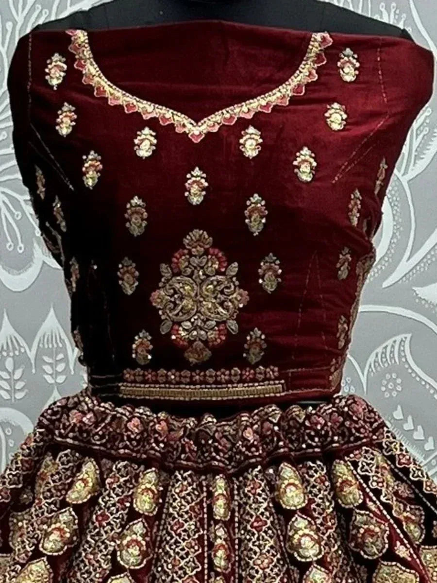 Maroon velvet lehenga choli with gold embroidery, perfect for Indian weddings and festive occasions.