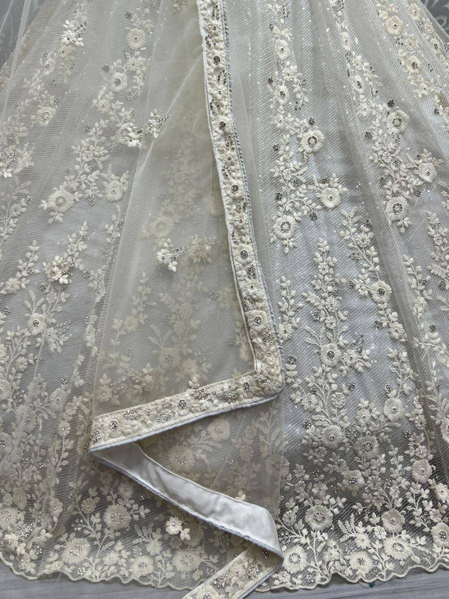 Elegant ivory lehenga with floral embroidery and sequin detailing, perfect for Indian weddings and festive occasions.