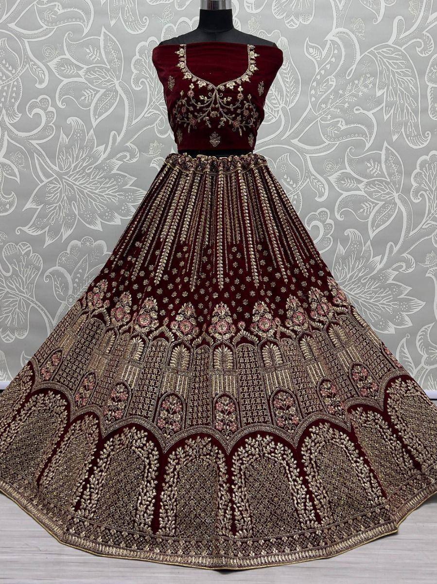 Maroon velvet lehenga choli with gold embroidery, perfect for Indian weddings and festive occasions.