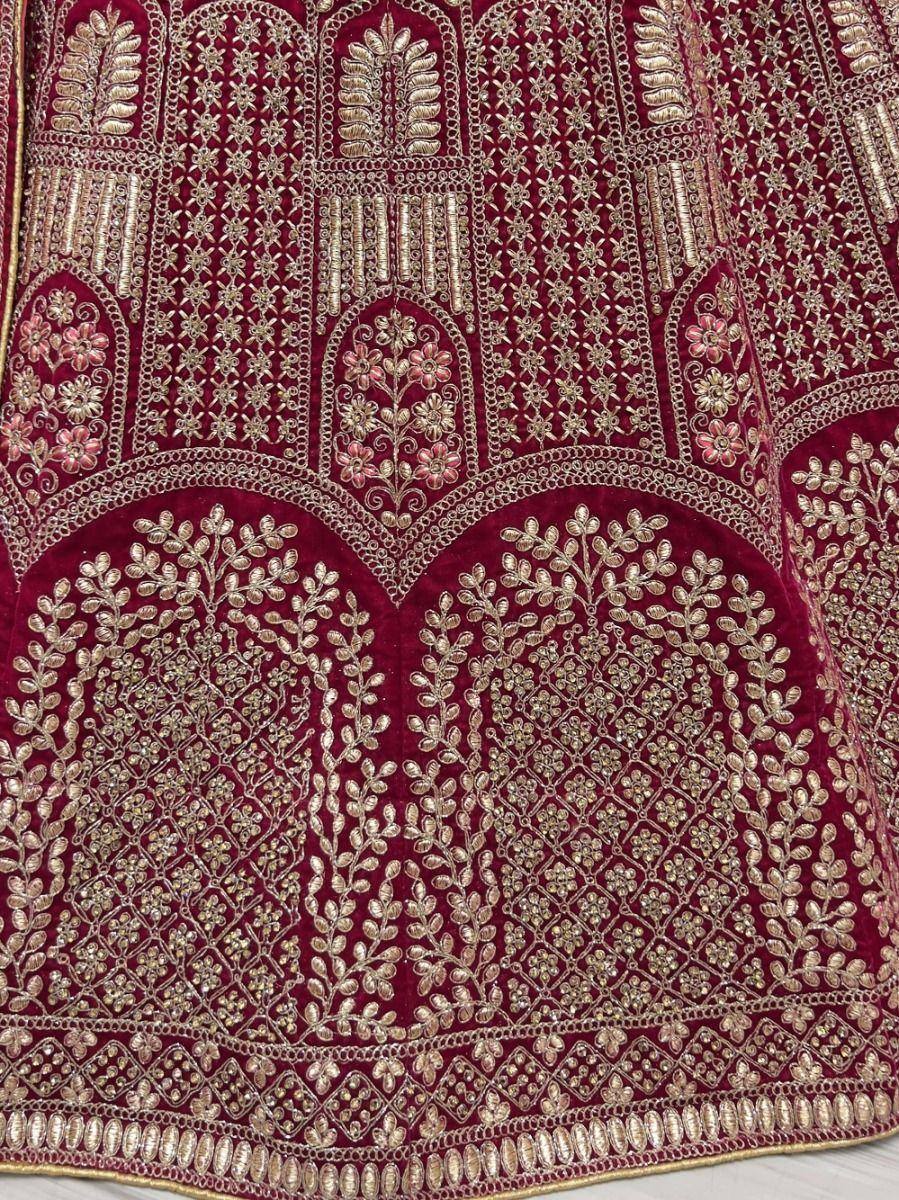 Maroon velvet lehenga with gold floral embroidery and intricate zari work, perfect for Indian weddings.
