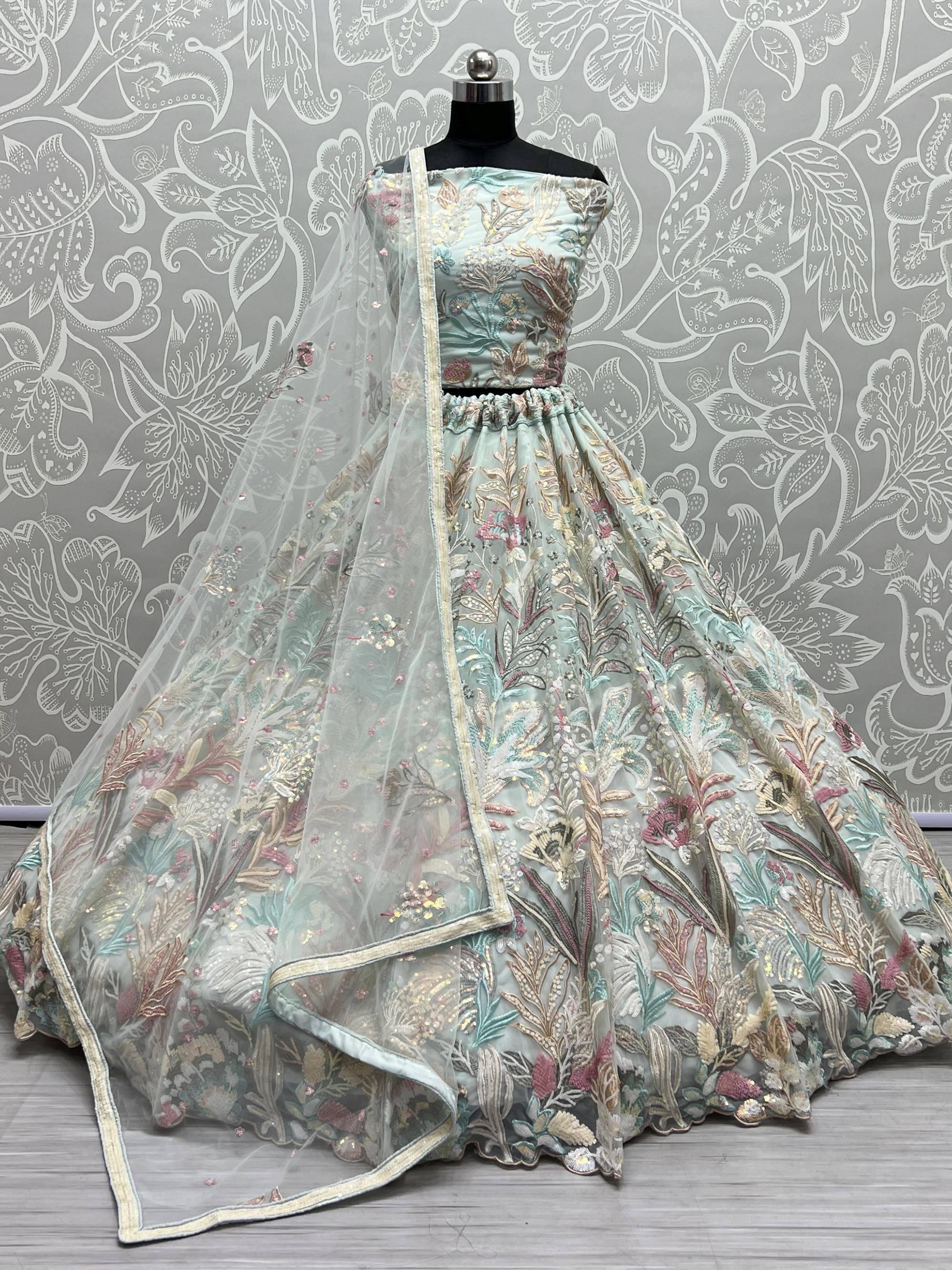 Mint green designer lehenga choli with floral embroidery and sheer dupatta, perfect for Indian ethnic wear occasions.