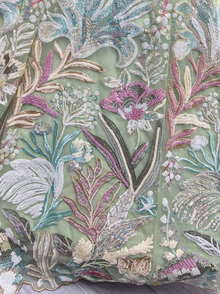 Intricate floral embroidery with sequins on mint green ethnic wear fabric, perfect for designer lehengas or gowns.