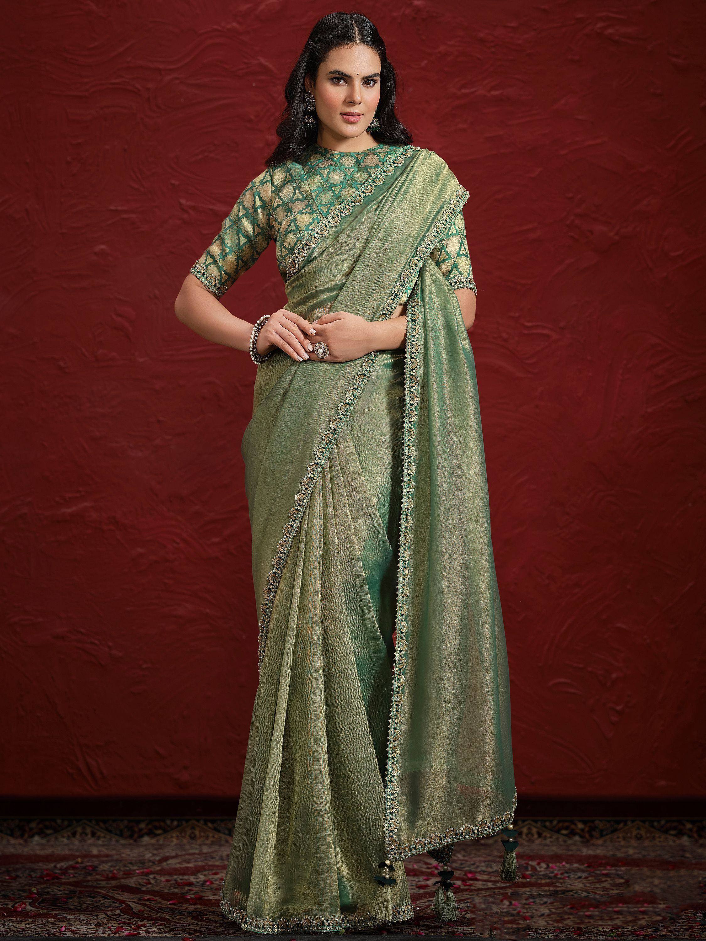 Elegant green designer saree with gold embroidery and tassels, perfect for Indian ethnic wear occasions.