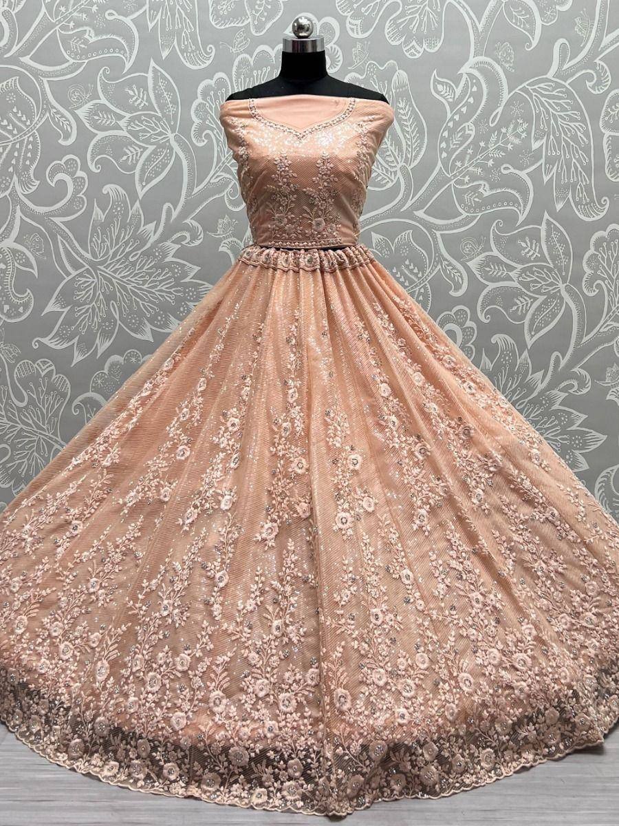 Elegant peach designer lehenga choli with floral embroidery, perfect for Indian weddings and festive occasions.