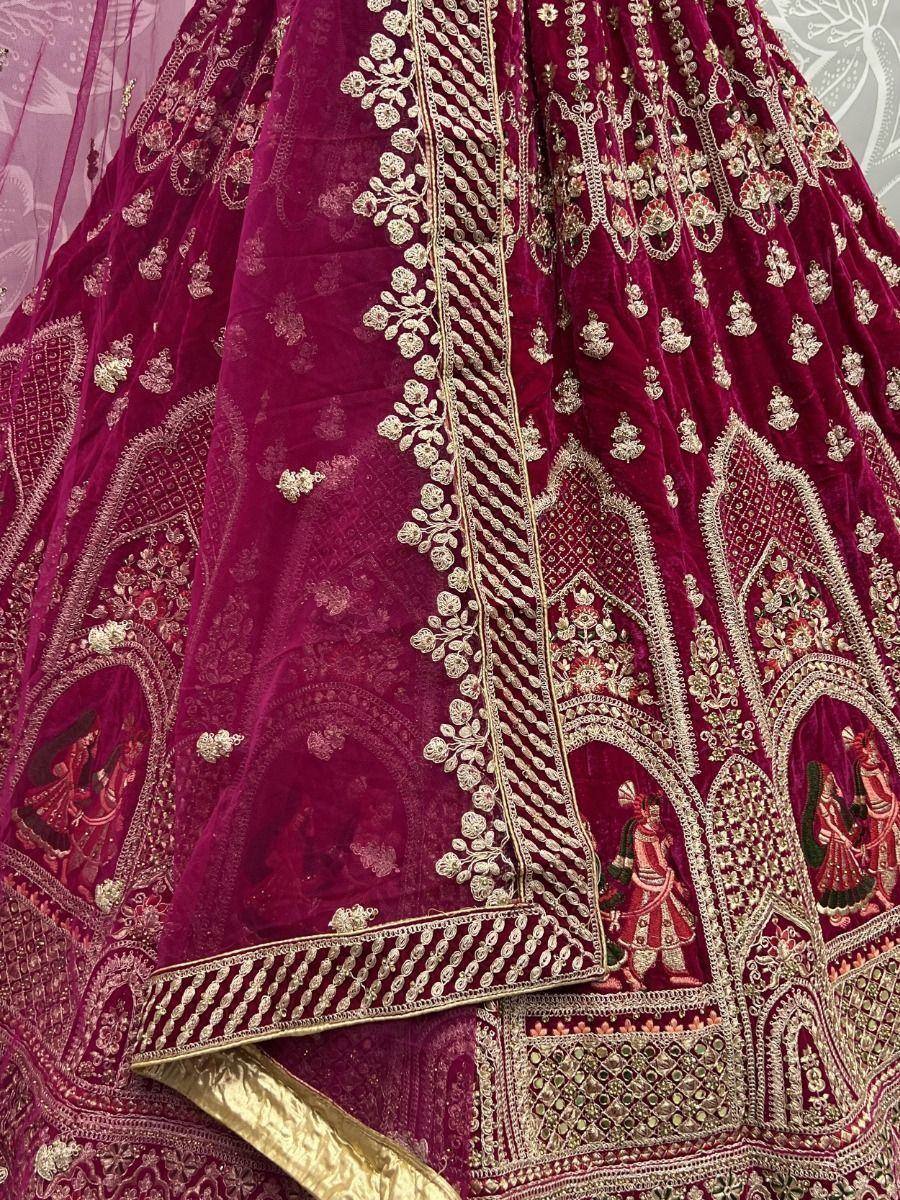 Luxury maroon velvet lehenga with intricate gold embroidery and traditional motifs, perfect for Indian weddings.