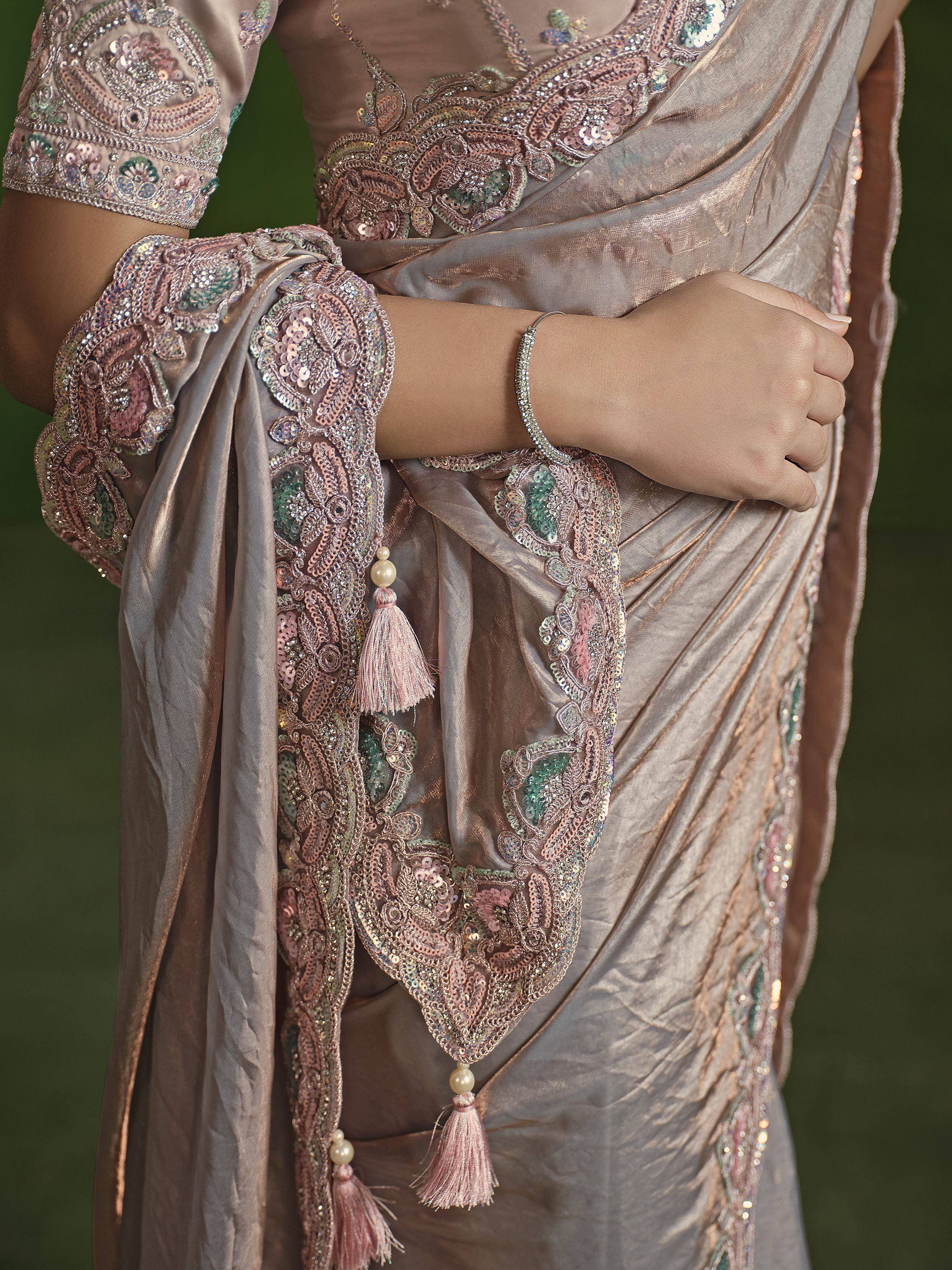 Elegant Indian saree with intricate sequin embroidery, tassels, and metallic sheen for festive occasions
