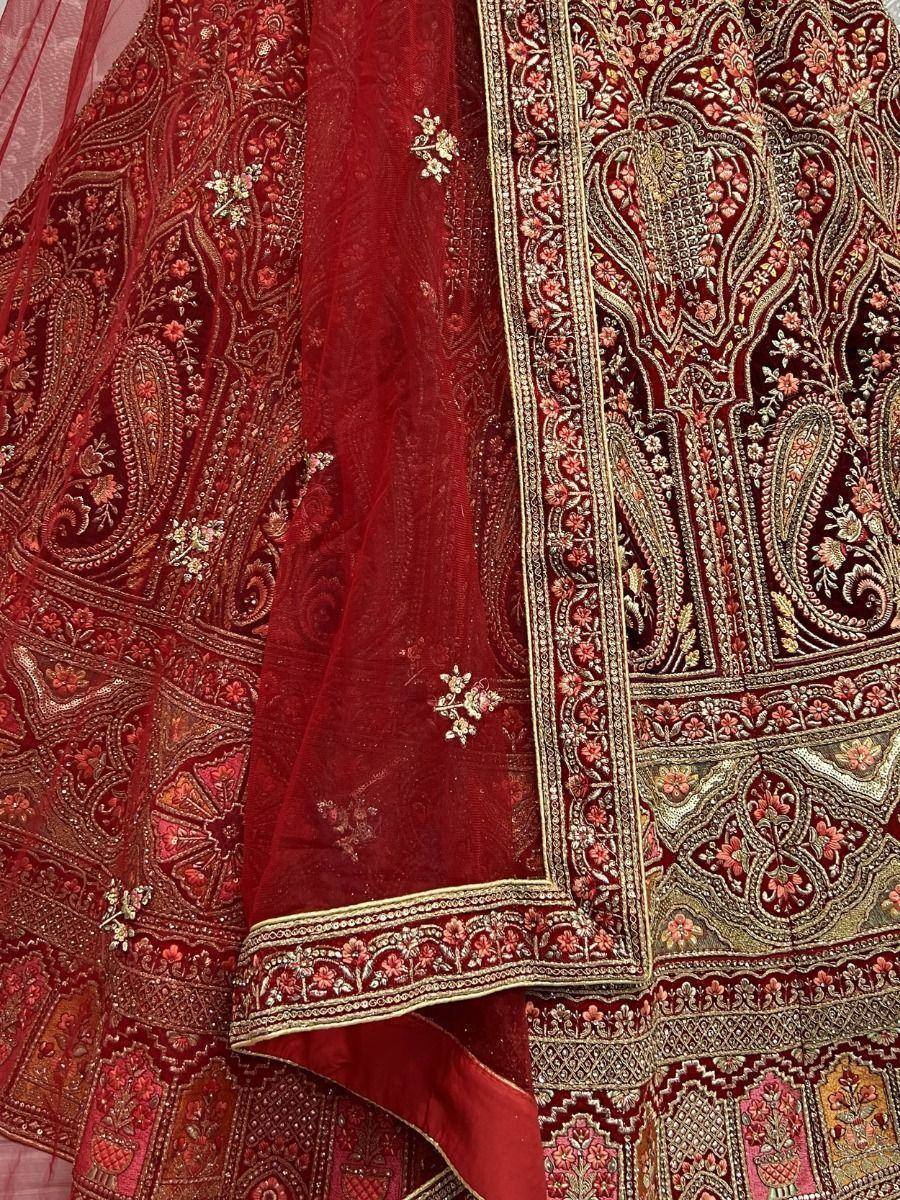 Rich red designer lehenga choli with intricate gold embroidery and paisley patterns, perfect for Indian ethnic wear.