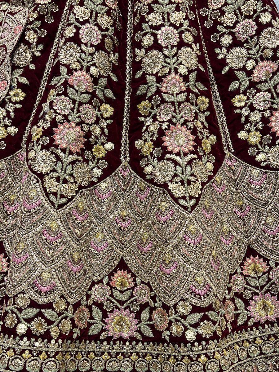 Luxury maroon velvet lehenga with intricate floral embroidery and gold pink detailing for Indian ethnic wear