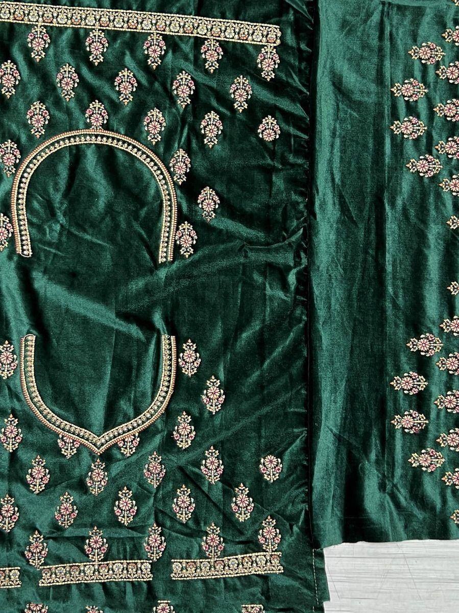Emerald green velvet salwar kameez with floral embroidery and gold detailing, perfect for ethnic occasions.