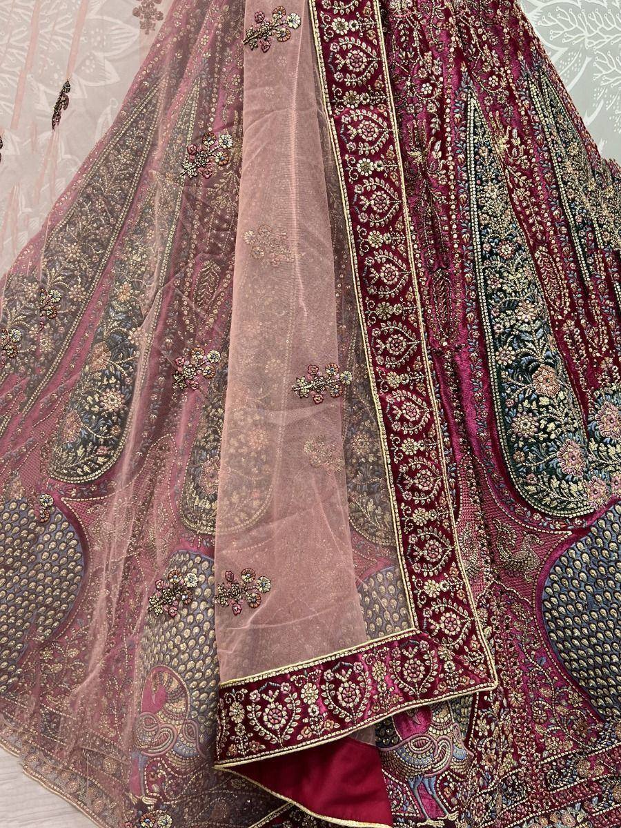 Luxury maroon lehenga choli with intricate gold embroidery and sheer dupatta, perfect for Indian weddings and festive occasions.