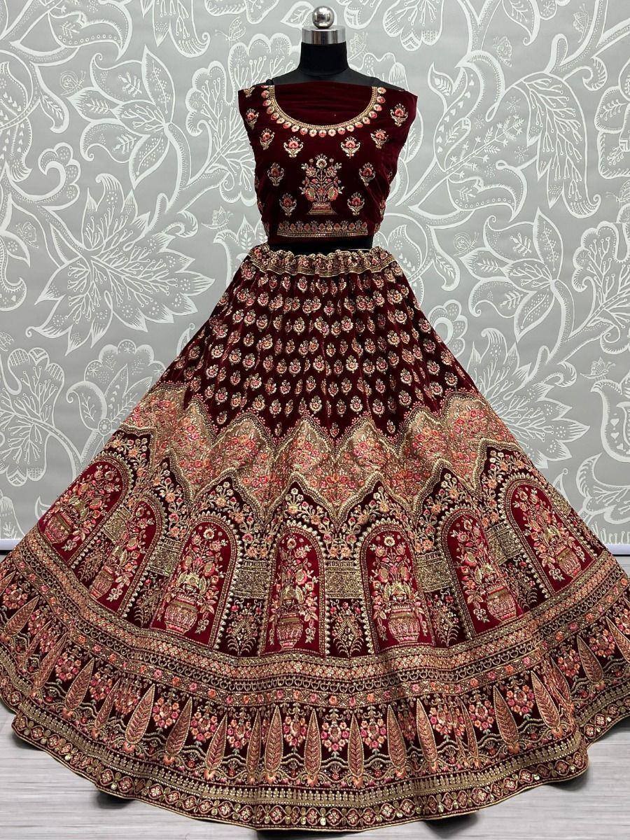 Maroon velvet lehenga choli with heavy gold embroidery, perfect for Indian weddings and festive occasions.