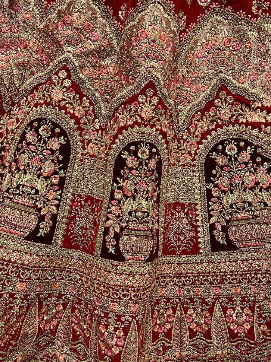 Richly embroidered red velvet lehenga with floral motifs and gold detailing, perfect for Indian ethnic wear.