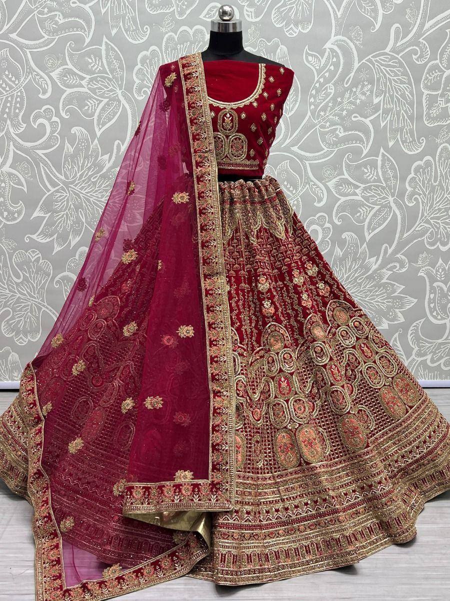Maroon designer lehenga choli with gold embroidery and net dupatta, perfect for Indian weddings and festive occasions.
