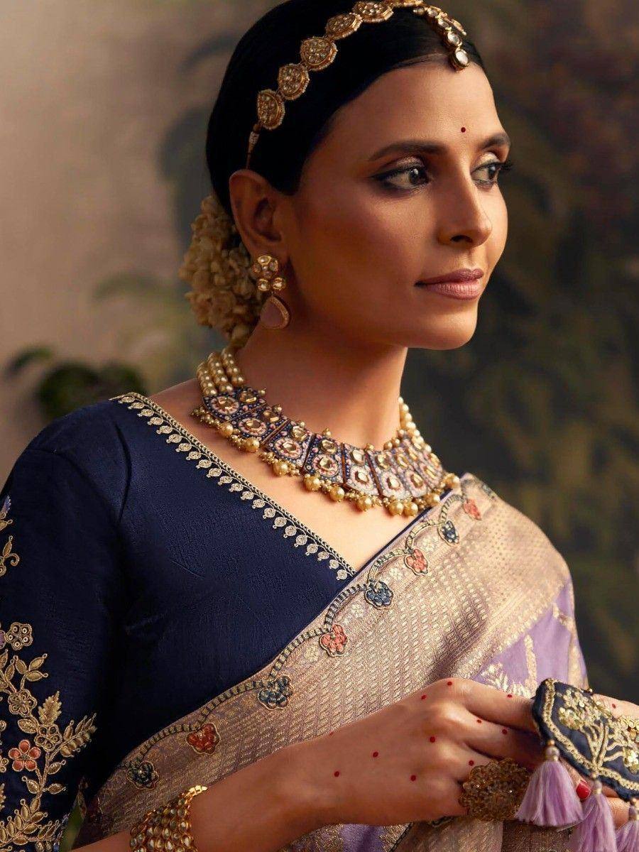 Elegant Indian woman in navy blue embroidered blouse and floral saree with traditional gold jewelry