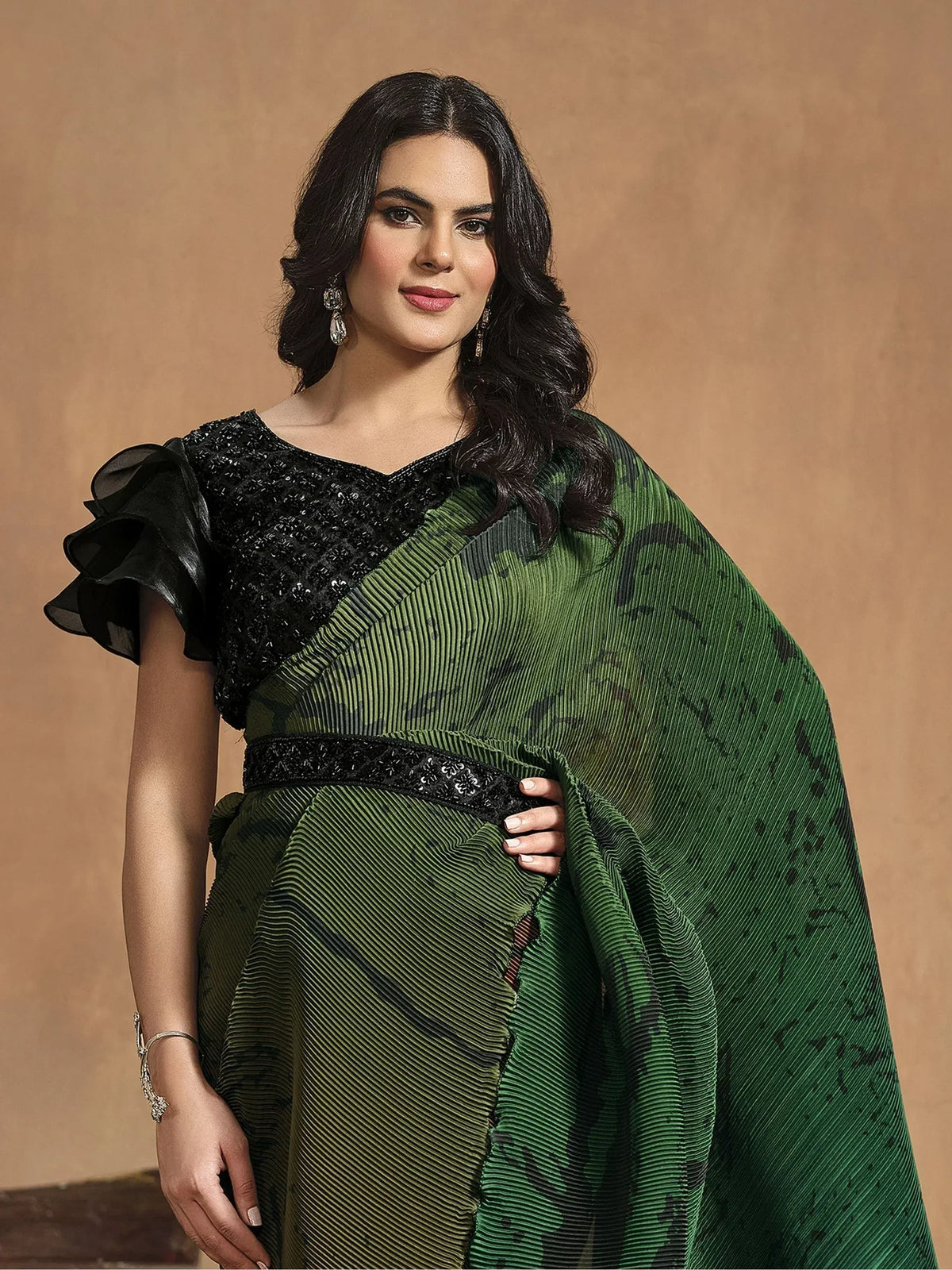Elegant green pleated saree with black sequined blouse and ruffled sleeves