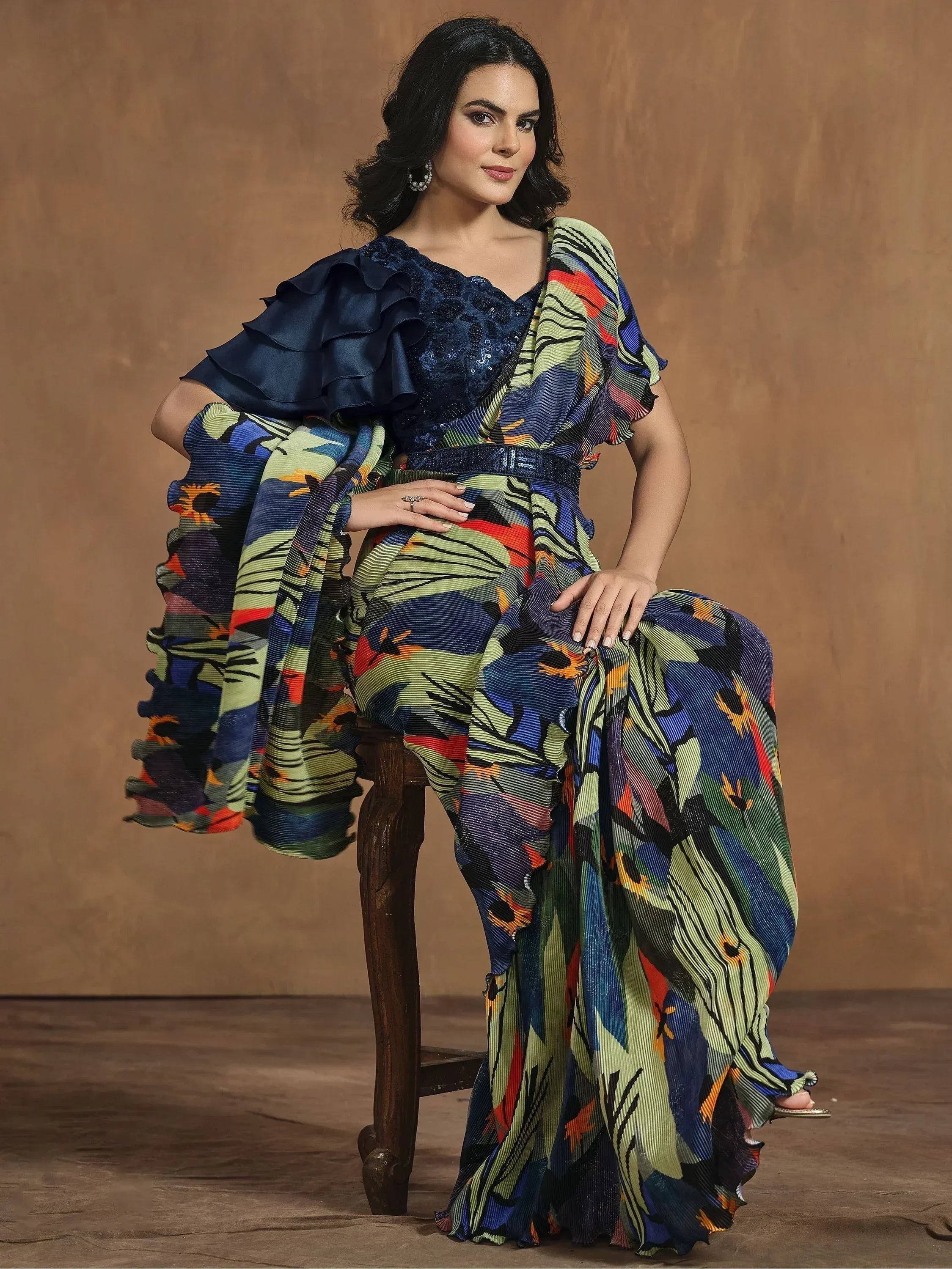 Woman in vibrant printed saree with ruffled navy blouse, ethnic Indian wear