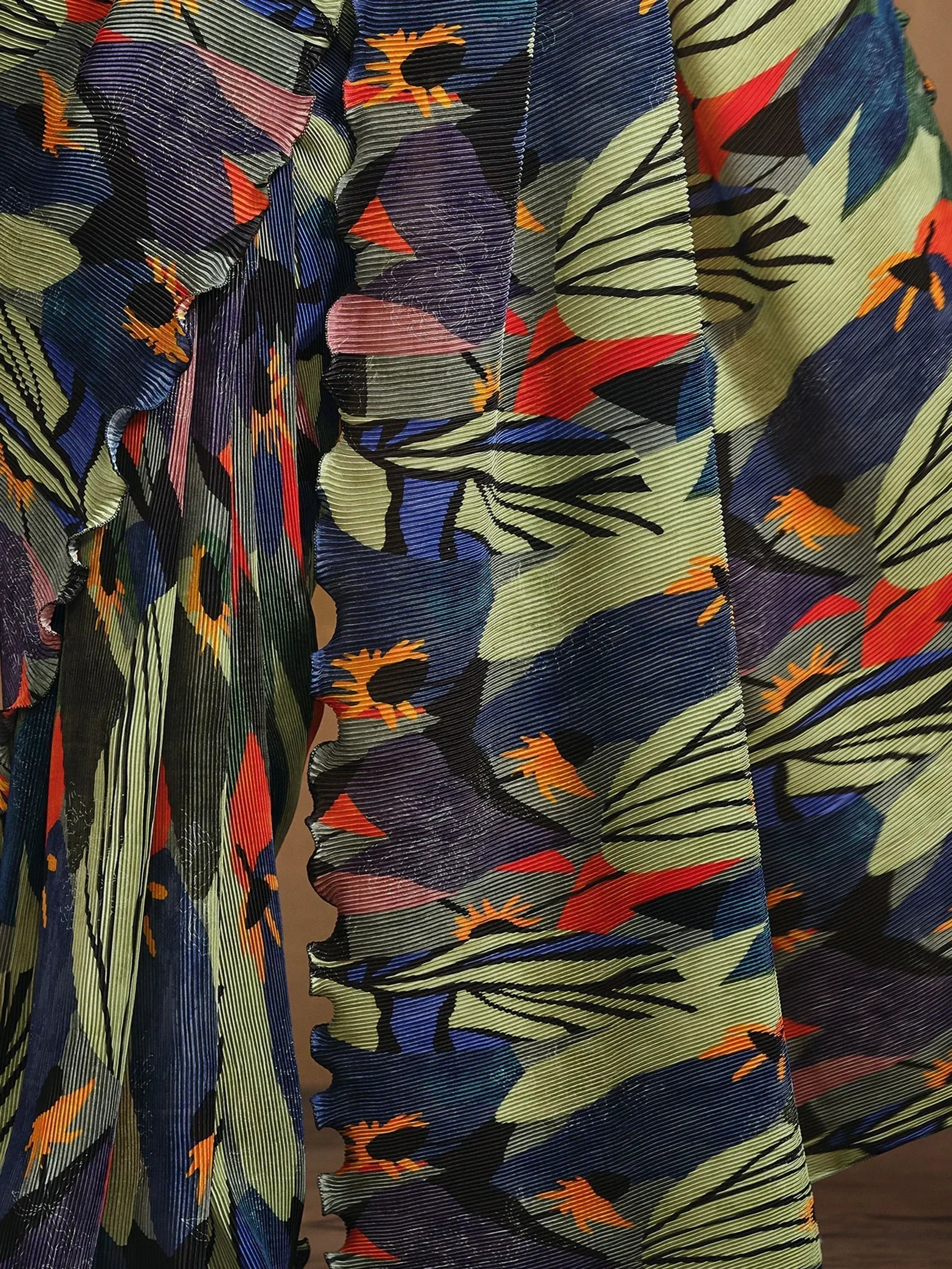 Vibrant floral print ethnic gown with pleated fabric and bold colors for festive occasions