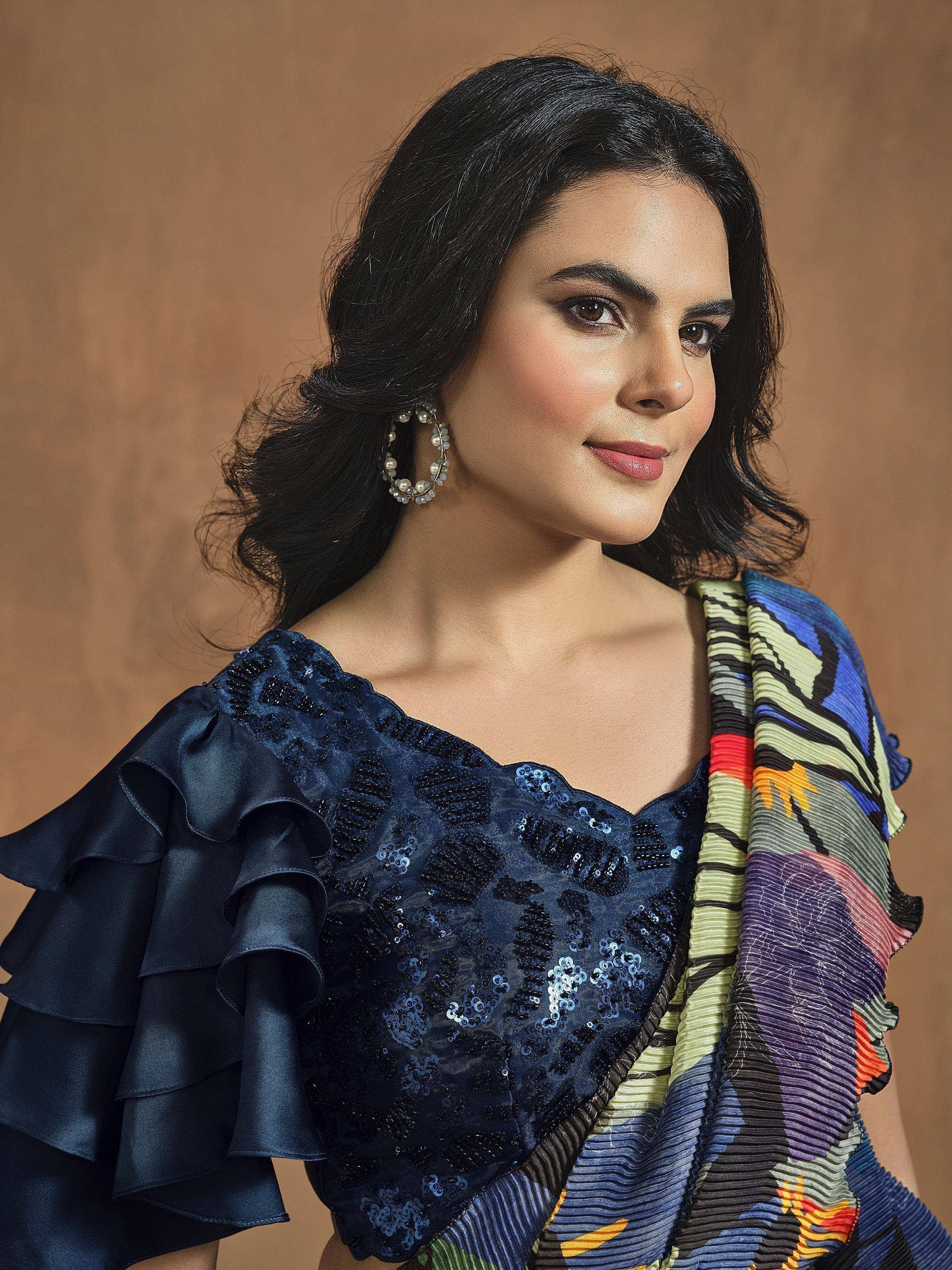 Woman in navy sequin blouse with ruffles & colorful printed saree, ethnic Indian wear
