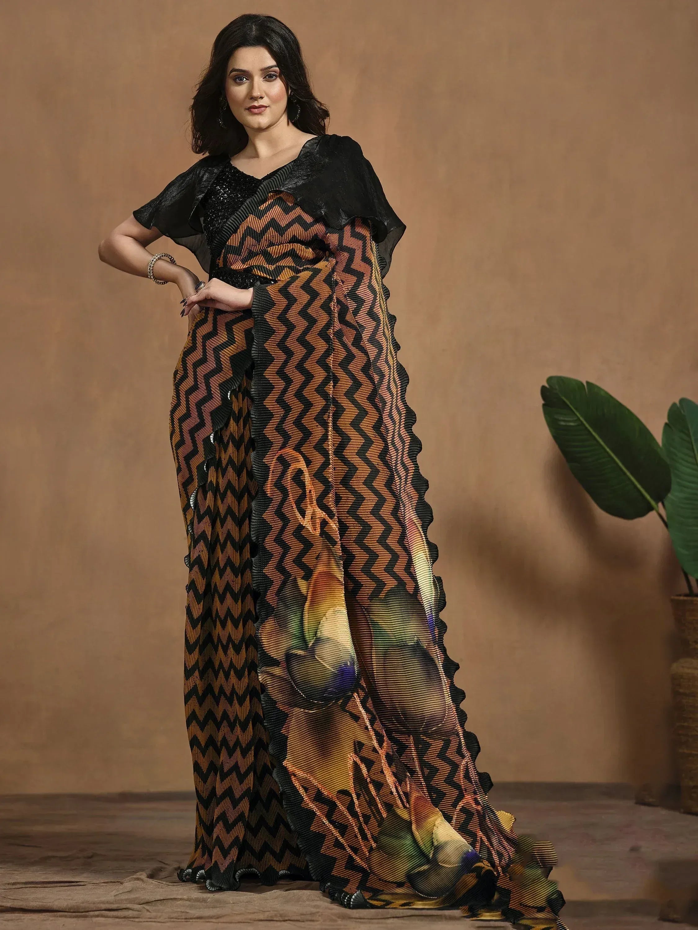 Woman in black and orange chevron print saree with ruffled border, ethnic Indian wear