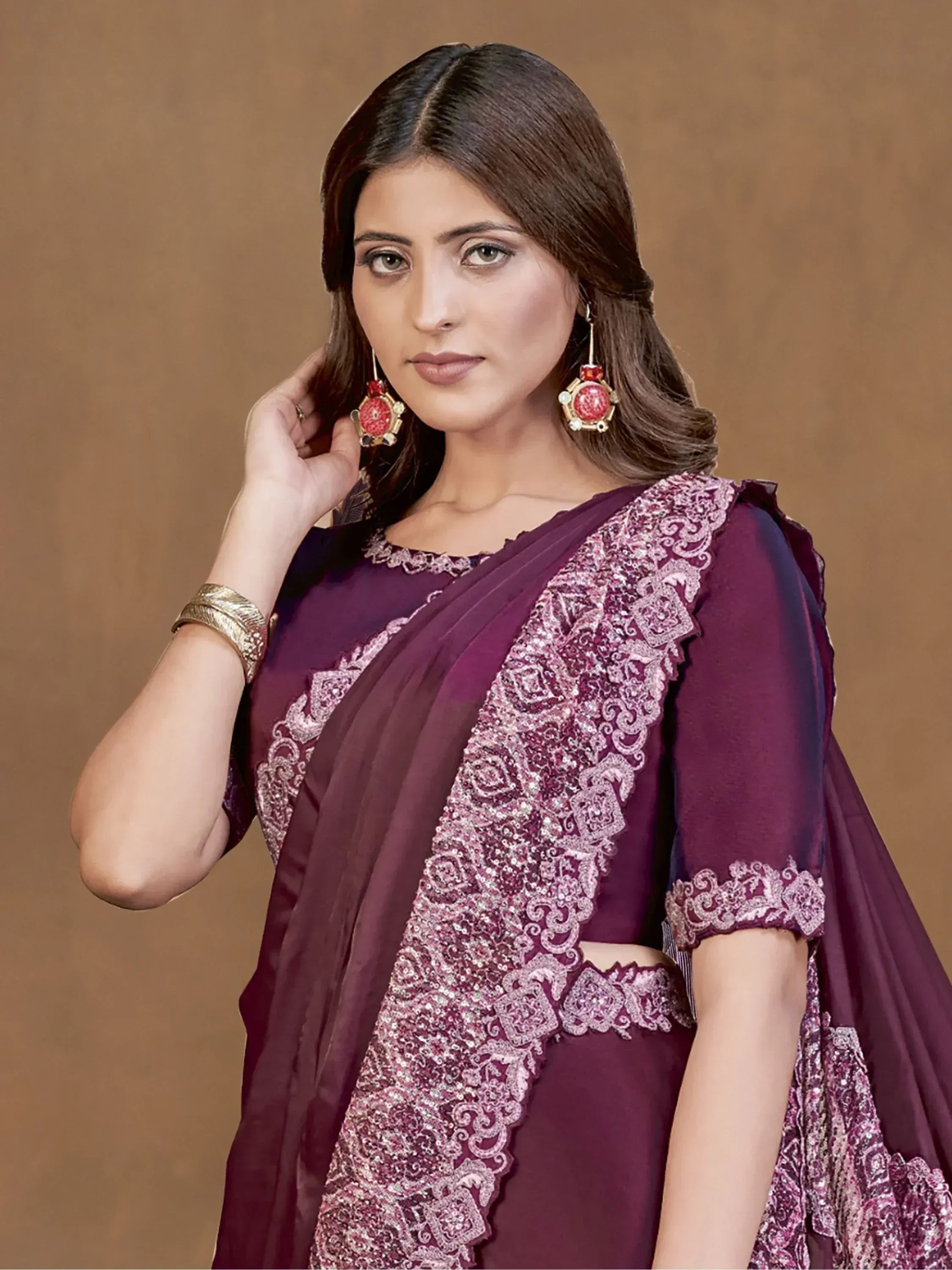 Elegant purple Indian saree with intricate embroidery and sequin work, paired with statement earrings