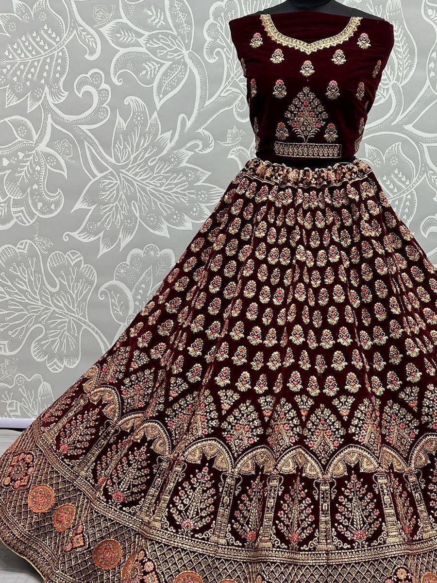 Maroon velvet lehenga choli with intricate gold and pink embroidery, perfect for Indian ethnic wear occasions.
