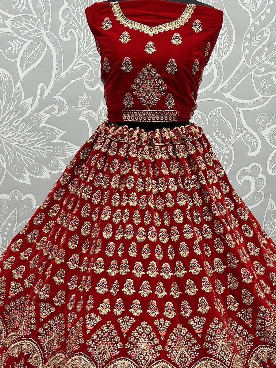 Red velvet lehenga choli with gold embroidery, perfect for Indian weddings and festive occasions.