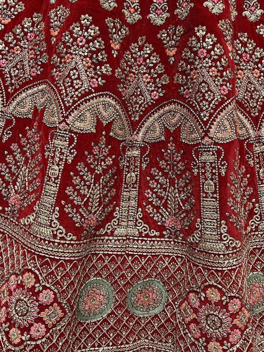 Rich maroon velvet lehenga with intricate floral embroidery and zari work, perfect for Indian ethnic wear.