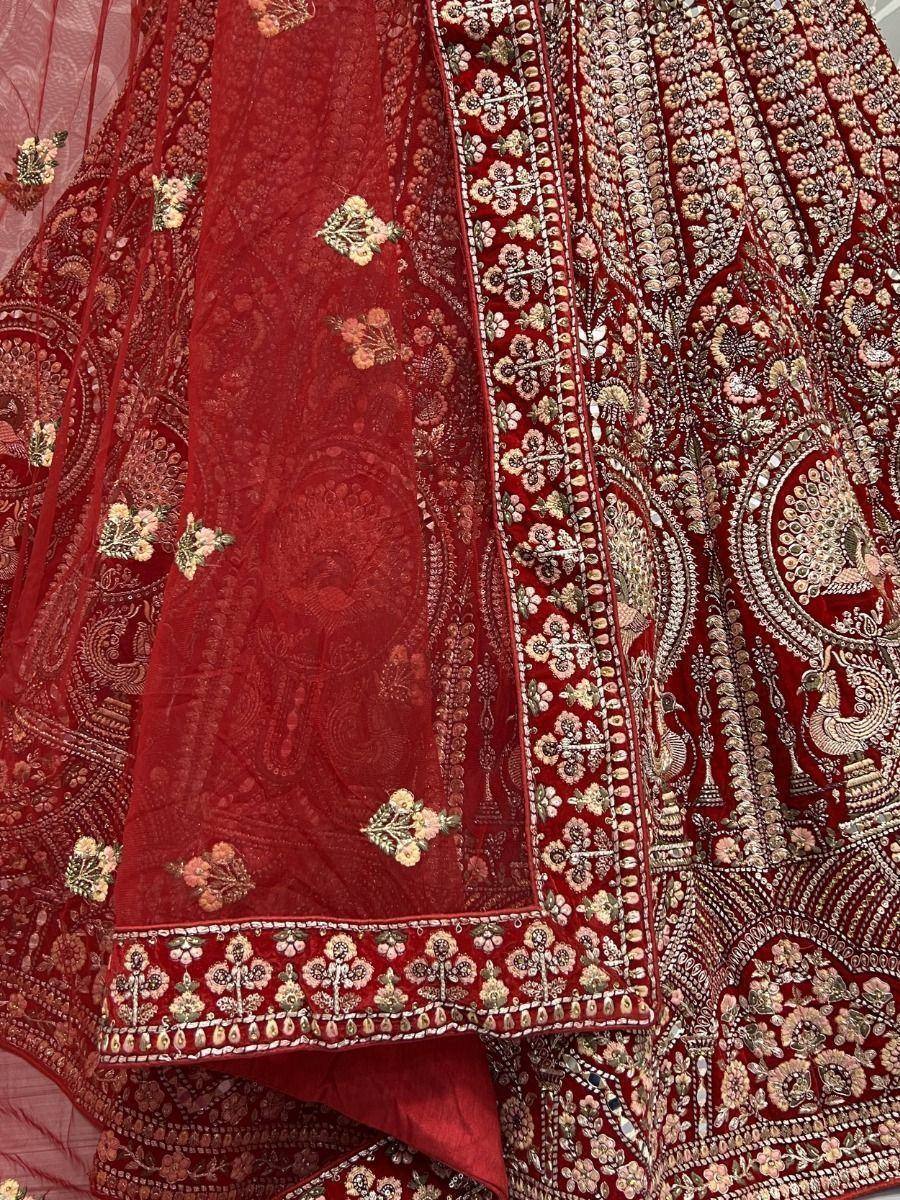 Rich red designer lehenga choli with intricate floral and peacock embroidery, perfect for Indian weddings.