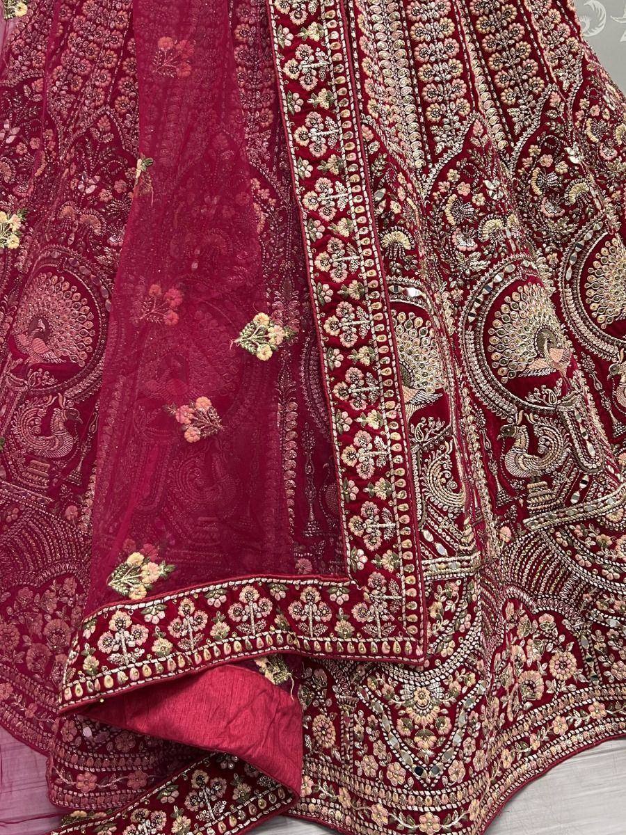 Rich maroon lehenga choli with intricate peacock embroidery and floral motifs, perfect for Indian weddings.