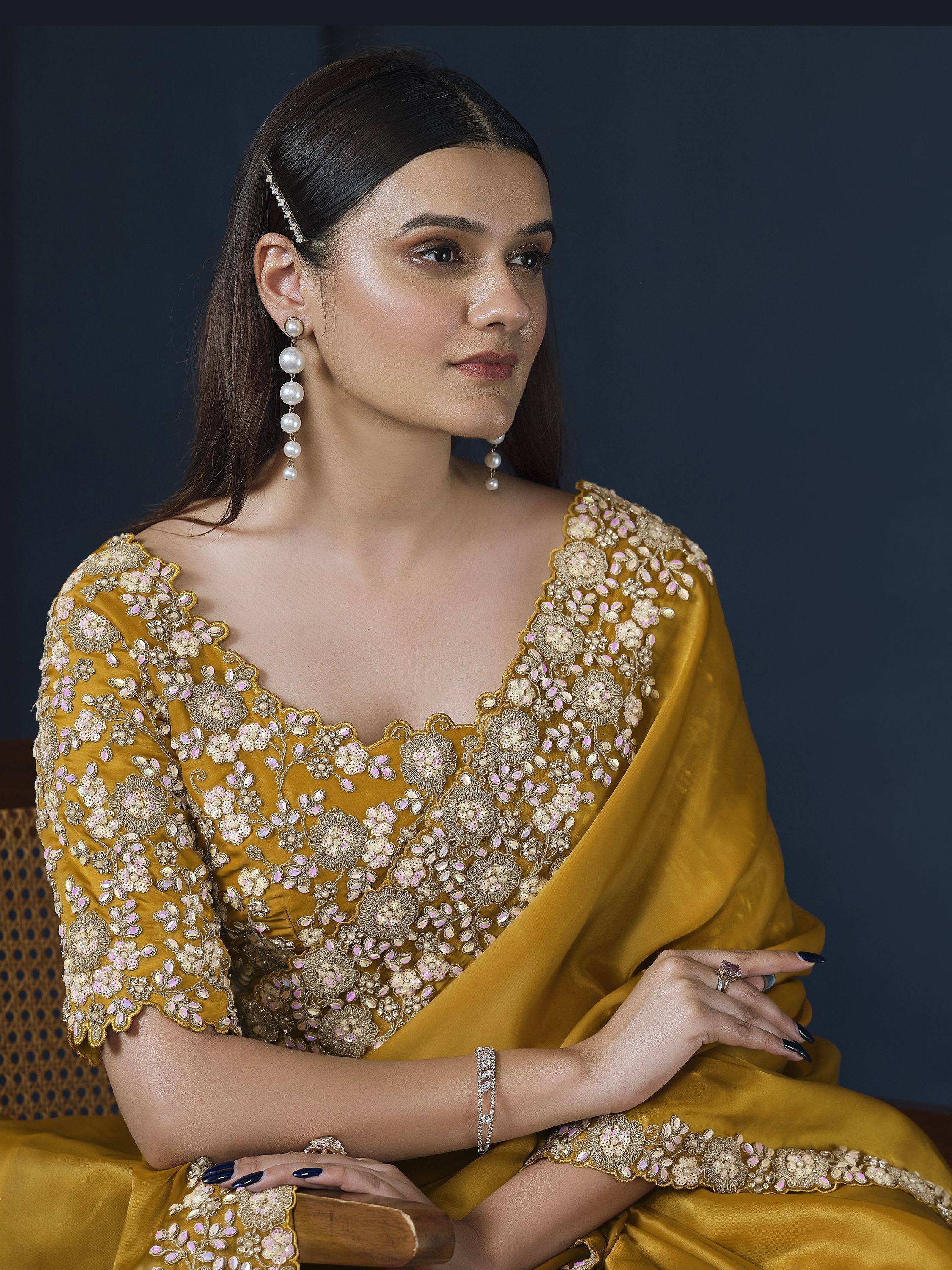 Elegant mustard yellow saree with floral embroidery and pearl jewelry for Indian ethnic wear