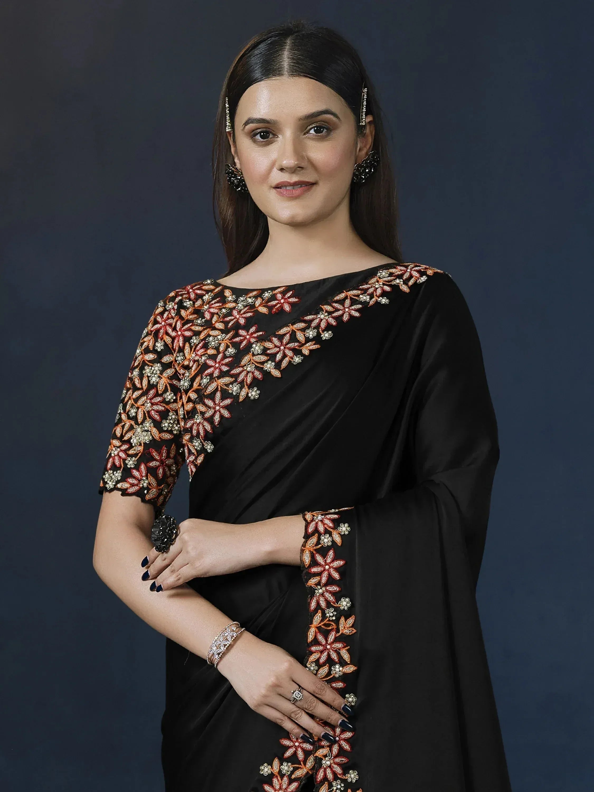 Black saree with orange floral embroidery, perfect for Indian ethnic wear occasions.