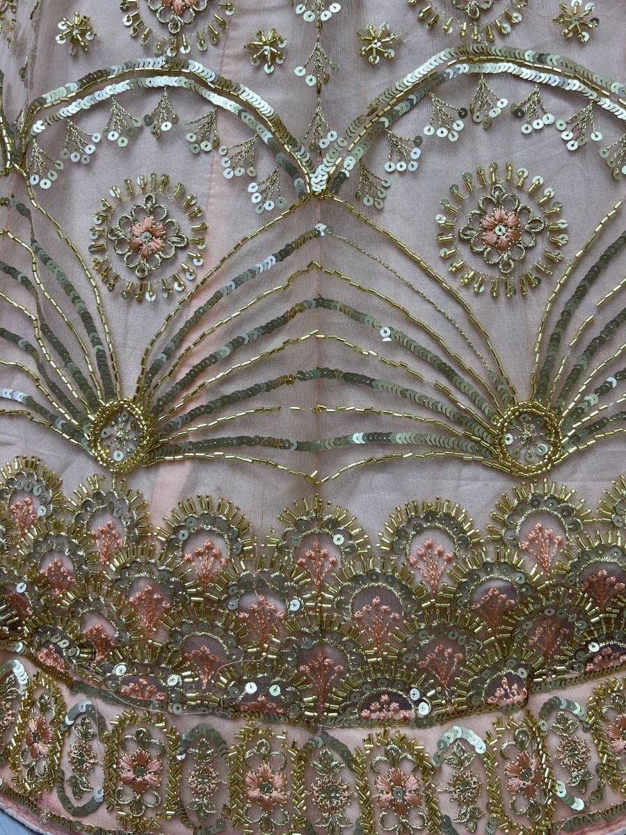 Pink ethnic gown with gold sequin and bead embroidery, floral motifs, and intricate detailing for festive occasions
