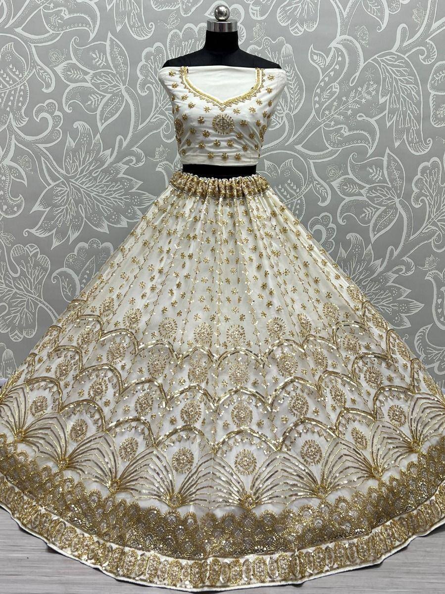 White and gold embroidered lehenga choli with intricate floral and scalloped detailing, perfect for Indian ethnic occasions.
