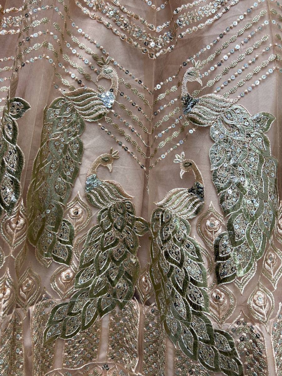 Elegant peacock-embroidered ethnic gown with sequin detailing, perfect for Indian festive wear.