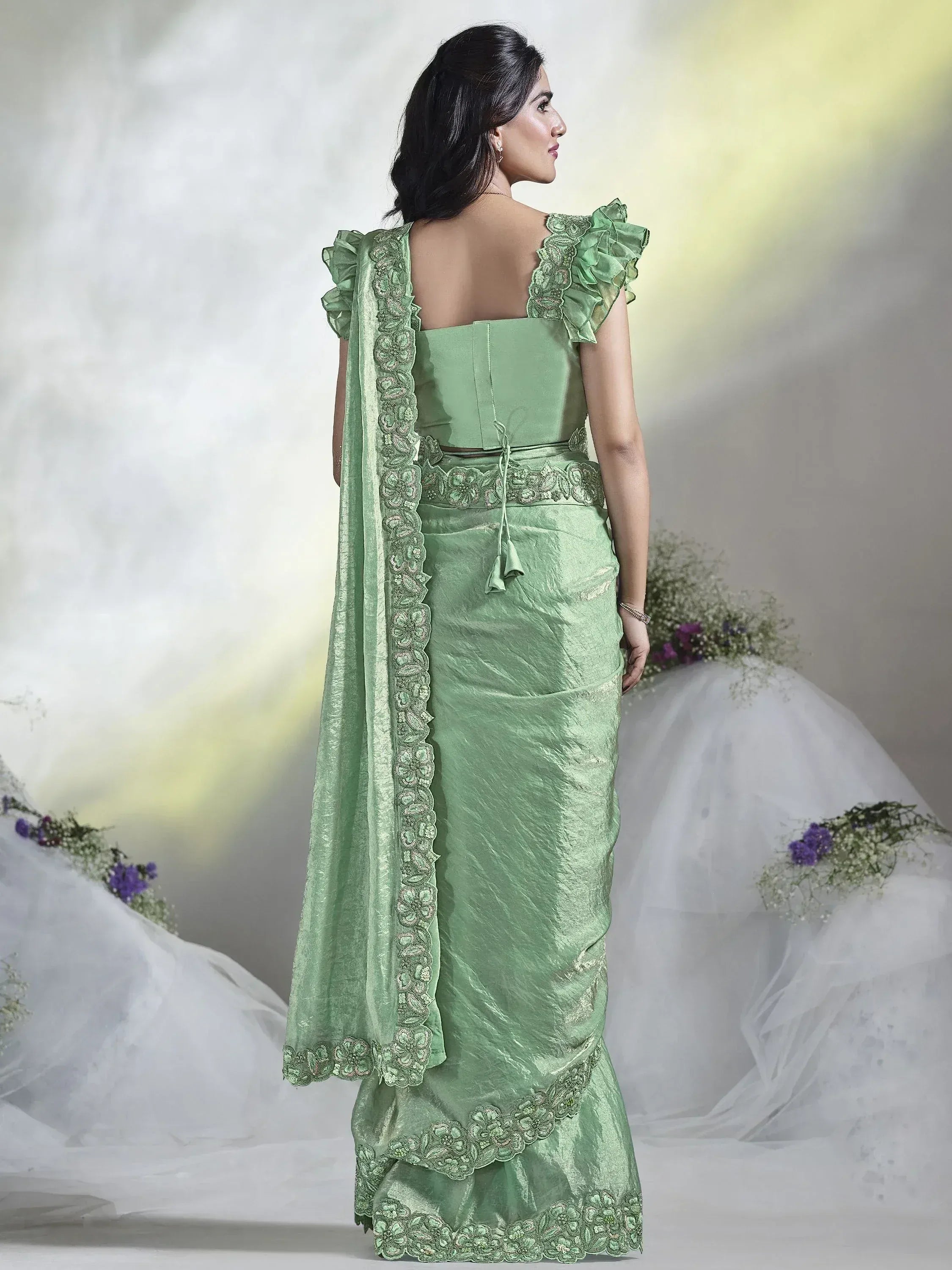 Mint green designer saree with ruffle sleeves and floral embroidery, perfect for ethnic occasions.