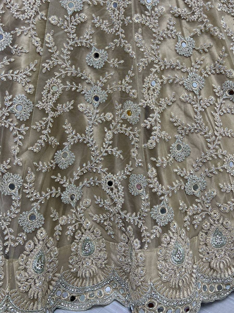Elegant beige lehenga with intricate silver embroidery and mirror work, perfect for Indian ethnic wear.