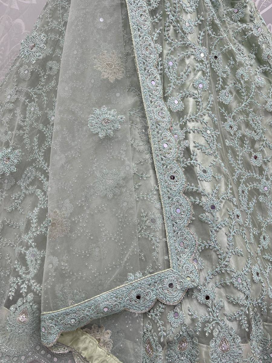 Mint green designer lehenga choli with intricate embroidery and mirror work, perfect for weddings and festive occasions.