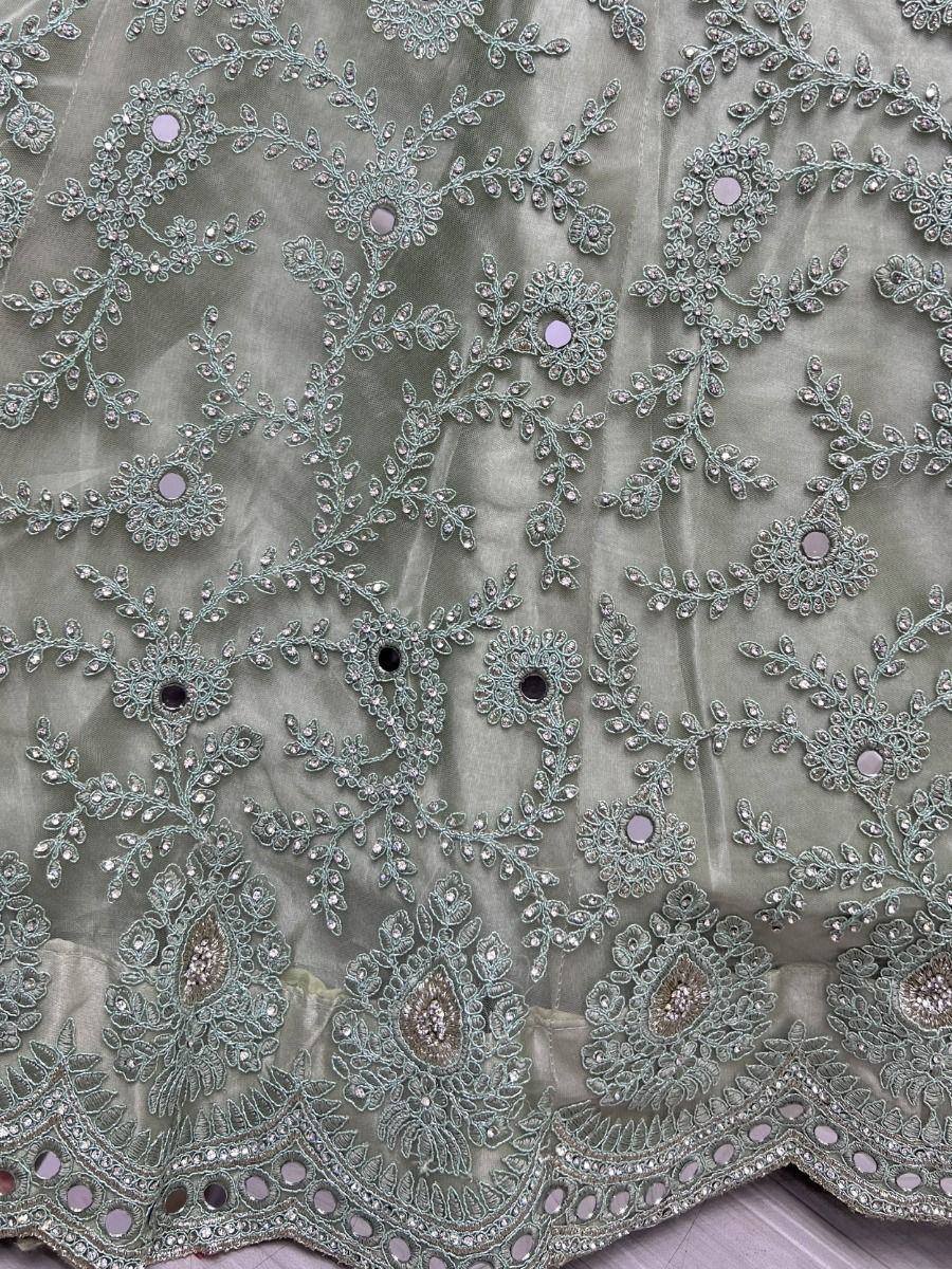 Elegant sage green ethnic wear with intricate floral embroidery and mirror work, perfect for designer lehenga or saree.